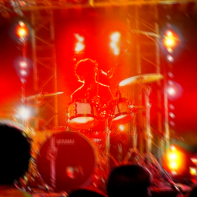 Raphaël Meyer le batteur de LAST RAINBOW lors des Vinestivales à Vinon-sur-Verdon. l'image est rouge et l'on distingue uniquement la silhouette bordée de jaune de l'incroyable batteur